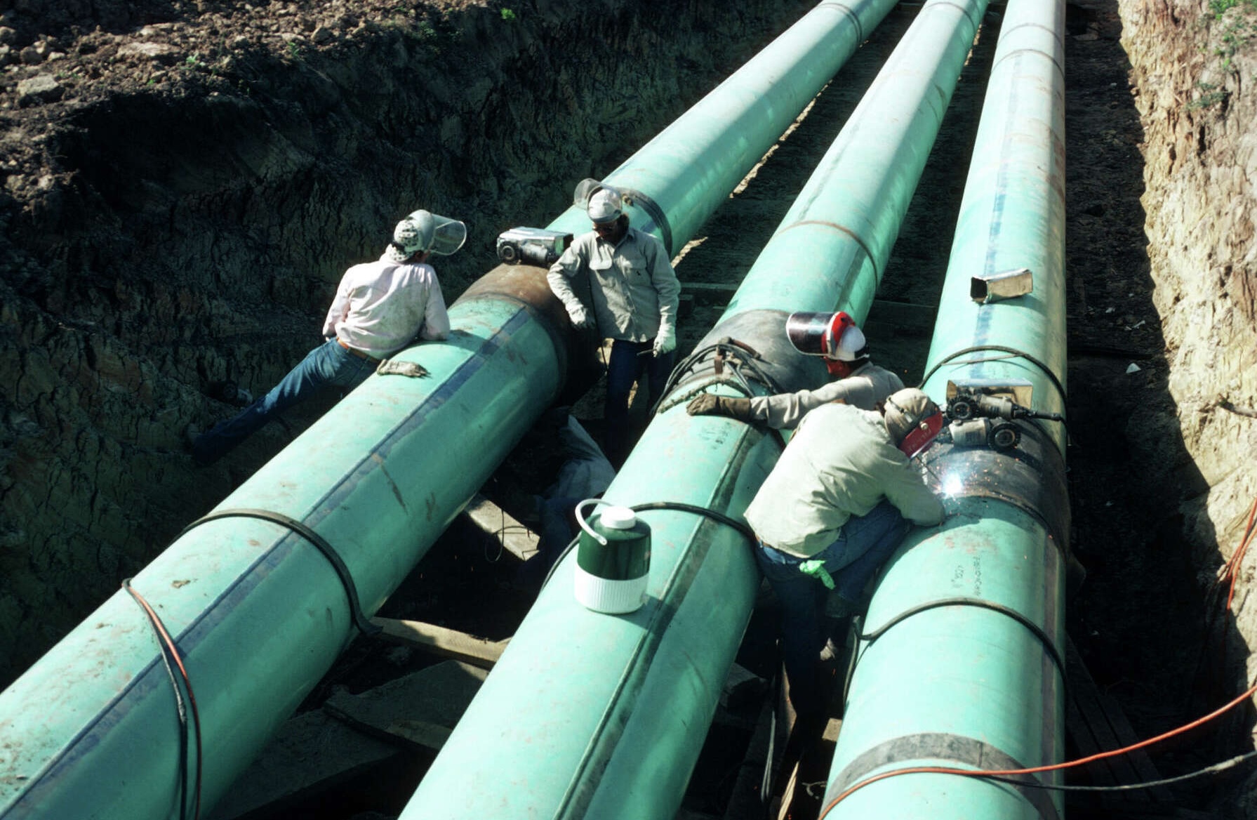 Pipeline construction crew welding large-diameter parallel pipelines